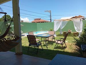 um pátio com uma mesa e cadeiras e uma piscina em Casa pertinho da praia com piscina, wifi; em Vila Velha