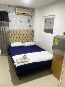 Dormitorio pequeño con cama con colcha azul en Del Castillo Mirador Hostel, en Cartagena de Indias