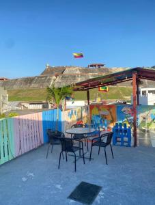 un patio con mesa y sillas frente a una pared en Del Castillo Mirador Hostel, en Cartagena de Indias