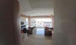 a living room with couches and a large window at Apartamento duplex, con terraza y vista de Chiclayo in Chiclayo