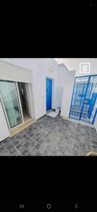 a room with a blue door and a tile floor at YoYo House in Sidi Bou Saïd
