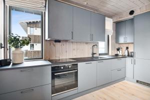 a kitchen with white cabinets and a large window at Hafjell Front 8pers, Ski in/out. Downhill Bike in Hafjell