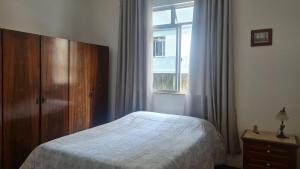 a bedroom with a bed and a window at Apartamento no Centro Parq Halfeld Juiz fora in Juiz de Fora