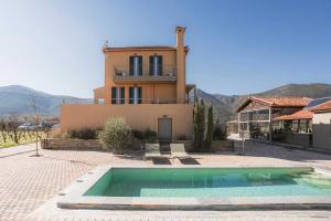 a house with a swimming pool in front of a house at Milea Agritourism - Farmhouse in Mantineia Arcadia in Kápsas