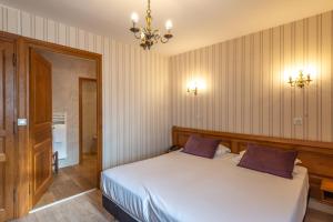 Postel nebo postele na pokoji v ubytování Hotel De La Cloche