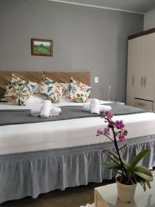 1 dormitorio con 1 cama grande con sábanas y almohadas blancas en CASA Próx Shopping Norte Londrina 2Qts Ar e CamaKing e Espacokids en Londrina
