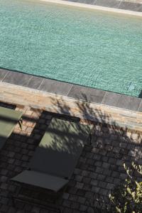 una vista sul tetto di una piscina con tavolo e acqua di Milea Agritourism - Farmhouse in Mantineia Arcadia a Kápsas