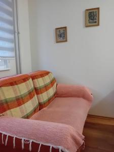 un sofá con 2 almohadas sentado en una habitación en Apartman A-1, en Zajecar