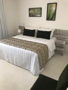 琵琶的住宿－GIRASSÓIS - Suítes，白色客房内的一张大床,配有一张大床和一张大型的四面 ⁇ 