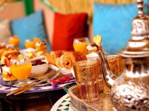 einen Tisch mit einem Frühstück mit Brot und Orangensaft in der Unterkunft Riad Dar Barae in Fès al Bali
