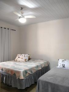 a bedroom with a bed and a ceiling fan at CASA INTEIRA MOBILIADA Próx Shopping Norte com Ar e Wifi , Selfie Checkin e Tv FireAmazon in Londrina