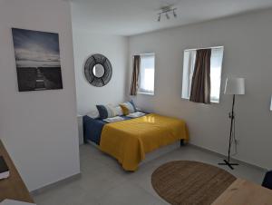 Canary's Suite في ماتوسينهوس: غرفة نوم بسرير وبطانية صفراء