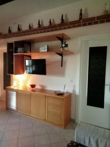 ein Wohnzimmer mit einem Flachbild-TV an der Wand in der Unterkunft La villa di campagna in Pisticci