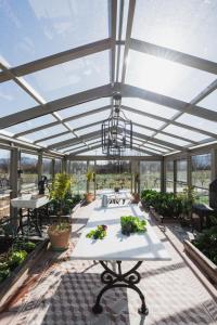 a greenhouse with a table and plants in it at Milea Agritourism - Farmhouse in Mantineia Arcadia in Kápsas
