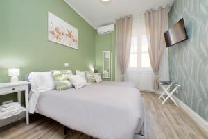 a bedroom with a large white bed and a television at PR APARTMENT - FIUMICINO ROME AIRPORT 9 Min - in Fiumicino