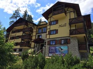 a large yellow building with wooden balconies on it at Vila Helena Hrabovo - Studio Helena 5 in Ružomberok