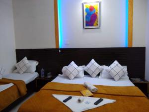 a hotel room with two beds with a tray on them at GRG Hotel Grace Agra in Agra