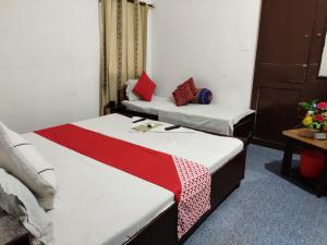 a room with two beds and a table with flowers at GRG Hotel Grace Agra in Agra