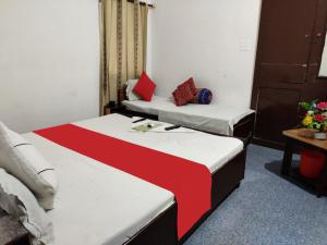 um quarto com duas camas com lençóis vermelhos e brancos em GRG Hotel Grace Agra em Agra