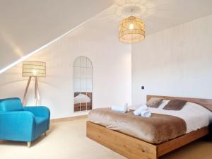 - une chambre avec un lit et une chaise bleue dans l'établissement L'Urbain YourHostHelper, à Cherbourg en Cotentin