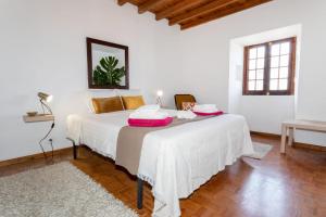 Un dormitorio con una cama y una mesa con toallas. en Casa dos Moinhos nearby the beach!, en Porto Formoso