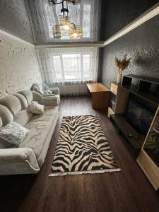 a living room with a couch and a zebra rug at Квартира по Республике 16/2 in Karagandy