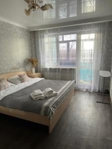a bedroom with a bed with two towels on it at Квартира по Республике 16/2 in Karagandy