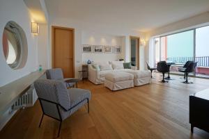 a living room with a white couch and chairs at The charming house in Taormina