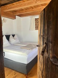 a bed in a room with a wooden door at Langrieshof in Rauris