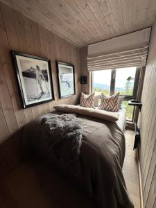 a bedroom with a large bed with pictures on the wall at Hafjell Front 8pers, Ski in/out. Downhill Bike in Hafjell