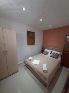 a bedroom with a large bed with two towels on it at Becic Apartments in Ulcinj