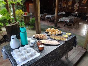 a table with plates of food and drinks on it at Pousada Li Art in Itapeva
