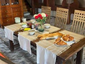Félines的住宿－Les chambres de Solol，一张木桌,上面有面包和鲜花