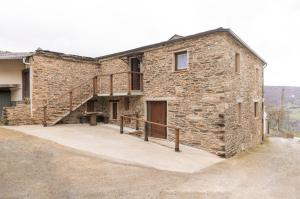 une maison en pierre avec un escalier sur son côté dans l'établissement Casa Rural Lar de Sanxes, à Lugo