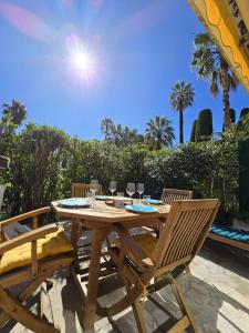 a wooden table and chairs on a patio at Le Week Riviera III -3 étoiles-Plage du midi-Grande terrasse-Piscine-Cannes- Palais des Festivals in Cannes