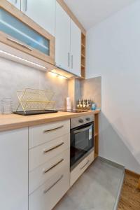 uma cozinha com armários brancos e um fogão em Erska 29 em Zlatibor