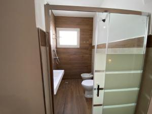bagno con servizi igienici, vasca e finestra di Residence Mariposa a Lido Conchiglia