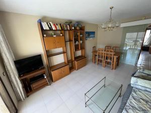 a living room with a television and a dining room at Playamar Altamar Apartments in Alcossebre