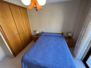a bedroom with a bed with a blue comforter at Playamar Altamar Apartments in Alcossebre +14 photos