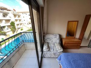 a bedroom with a balcony with a bed and a chair at Playamar Altamar Apartments in Alcossebre