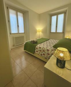 a bedroom with a bed and a table with a lamp at Apartment Menaggino in Menaggio