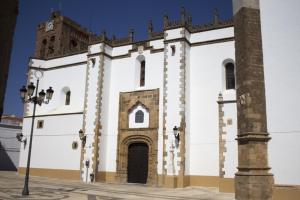 un edificio blanco con una torre de reloj encima en La Alcoba by Casa de Rosita AT-BA-00215 en Fuente del Maestre