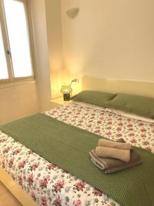 a bedroom with a large bed with a green comforter at Apartment Menaggino in Menaggio