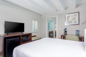 a bedroom with a bed and a flat screen tv at Bikini Beach Resort in Panama City Beach