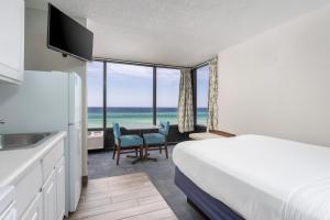 パナマ・シティ・ビーチにあるBikini Beach Resortのベッドとテーブルが備わる、眺めの良いホテルルームです。