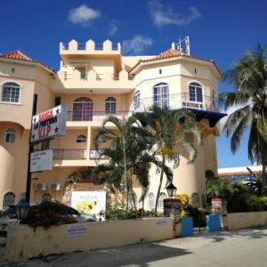 a large building with palm trees in front of it at Caribbean Paradise steps to DayPass Resort&Beach in La Laguna