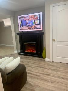 a living room with a fireplace with a flat screen tv at 1 bedroom in basement with private side entrance in Guelph