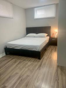 a bedroom with a bed and a wooden floor at 1 bedroom in basement with private side entrance in Guelph