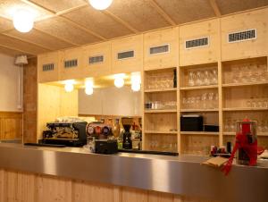 uma grande cozinha com um balcão e prateleiras com copos em Hôtel-Restaurant du Cerf em Les Ponts-de-Martel