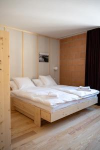 Les Ponts-de-MartelにあるHôtel-Restaurant du Cerfのベッドルーム1室(白い大型ベッド1台付)
